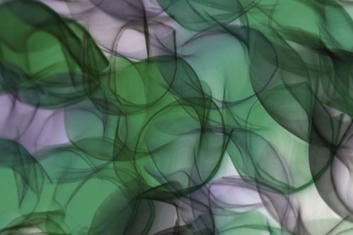 Free A creative blend of green and purple abstract shapes resembling smoke, creating a fluid artistic design. Stock Photo