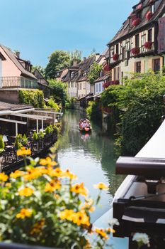 Beautiful sunny day on a canal in Colmar, France, featuring colorful houses and a boat ride.