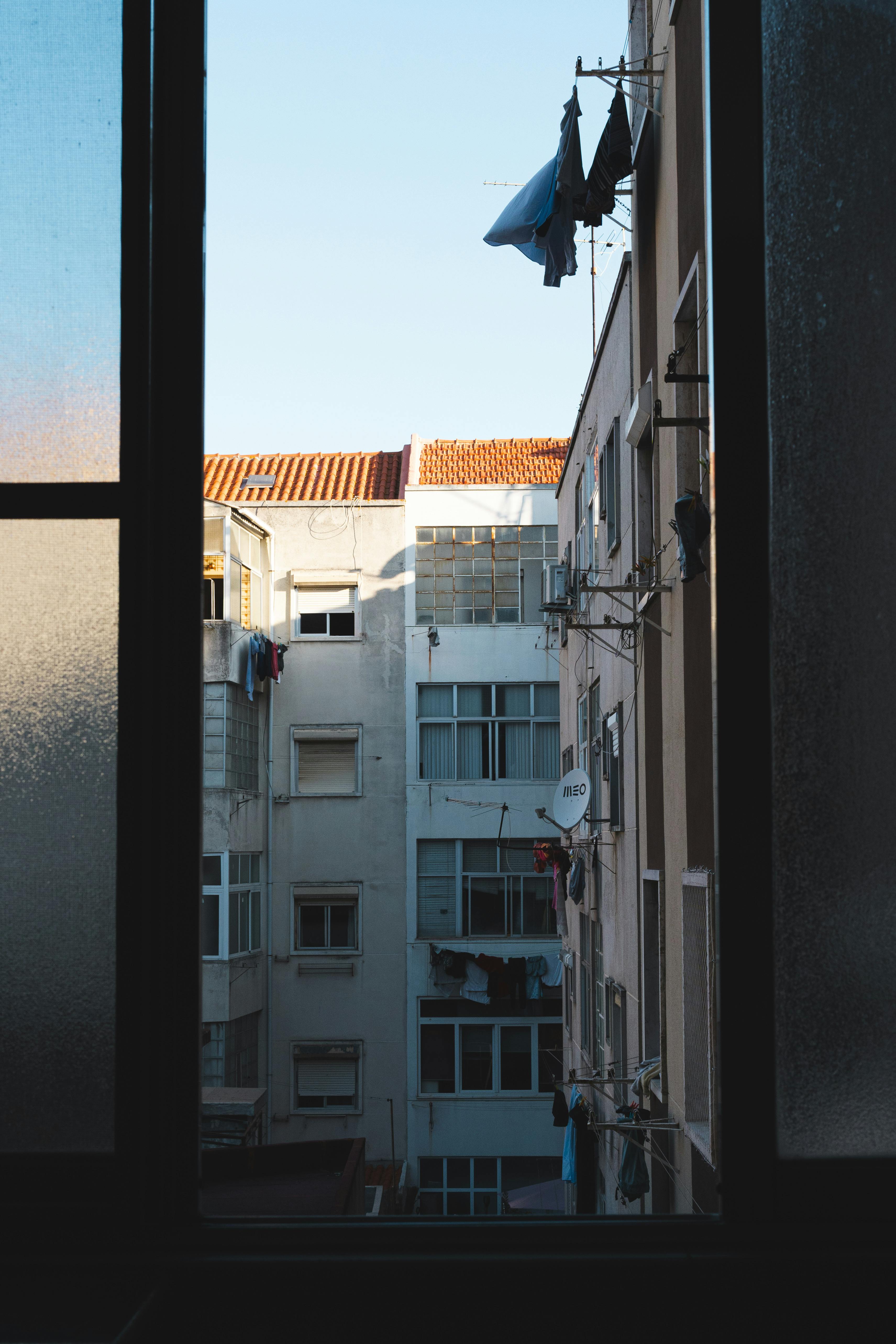 A scenic view of Lisbon's urban apartment buildings seen from a window, capturing local architecture.