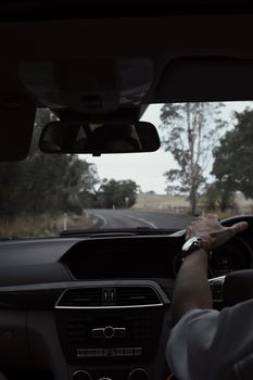 View from inside a car, driver on a winding countryside road.