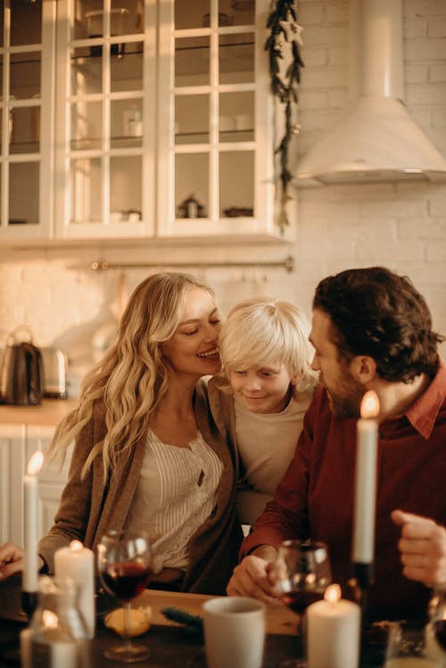 Free Boy Between Man and Woman Sitting Beside Table Stock Photo