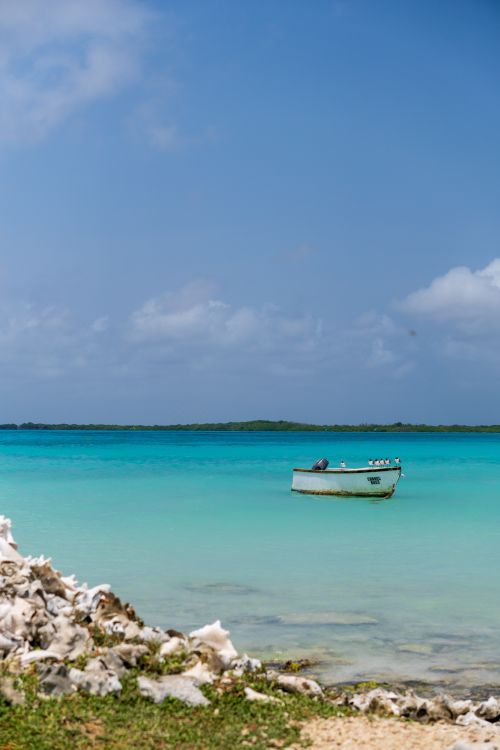 Free A tranquil view of a boat on the azure waters of Bonaire's coastline under a bright blue sky. Stock Photo
