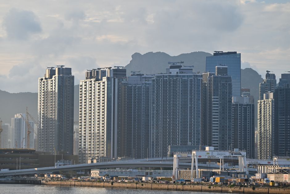 Cityscape featuring towering high-rise buildings against a mountainous backdrop.