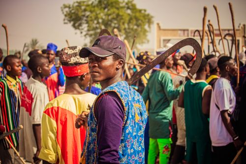 Free Vibrant outdoor festival with people in traditional clothing and decorative staffs. Stock Photo