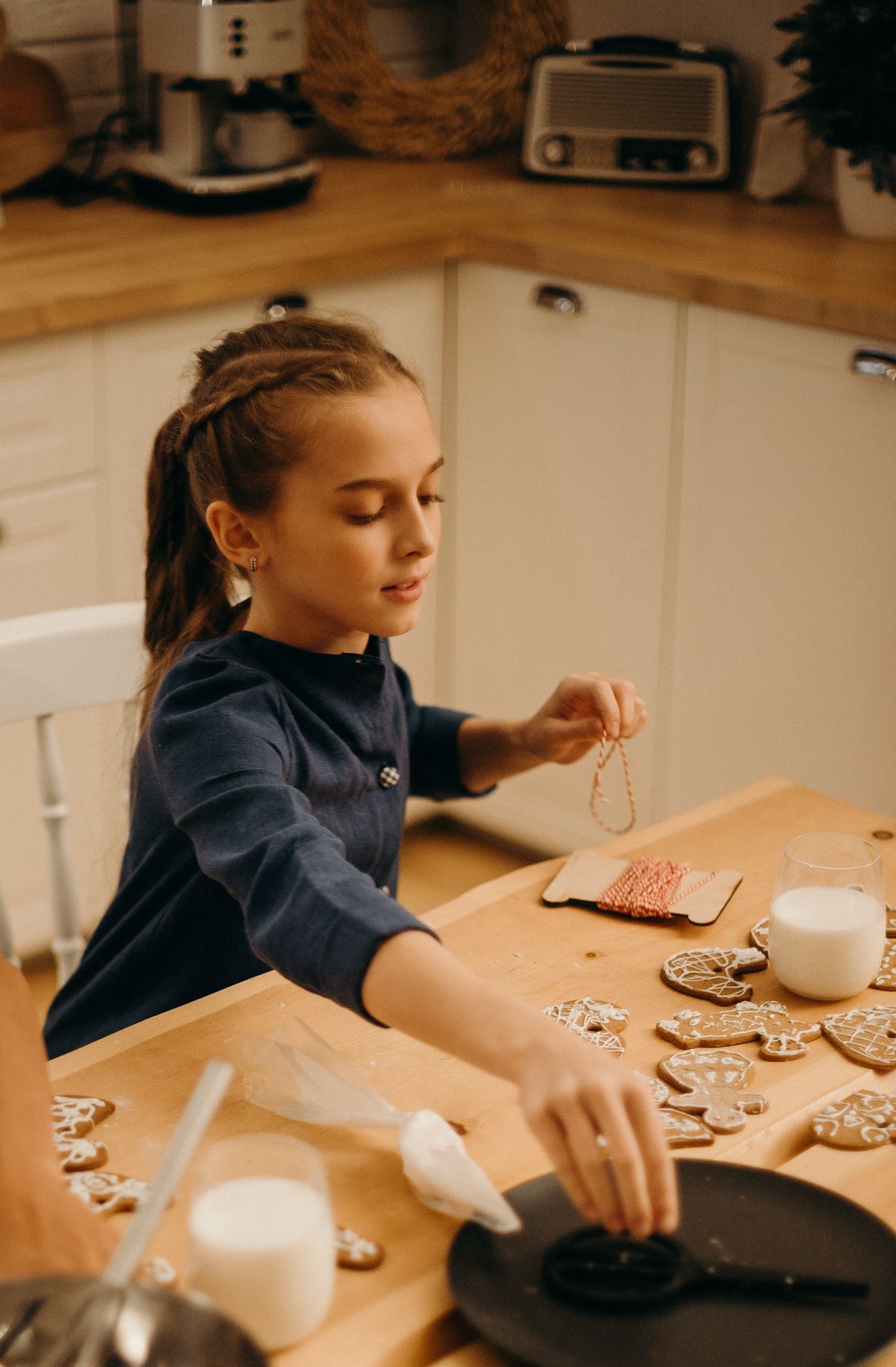 Girl decorating cookies in a kitchen