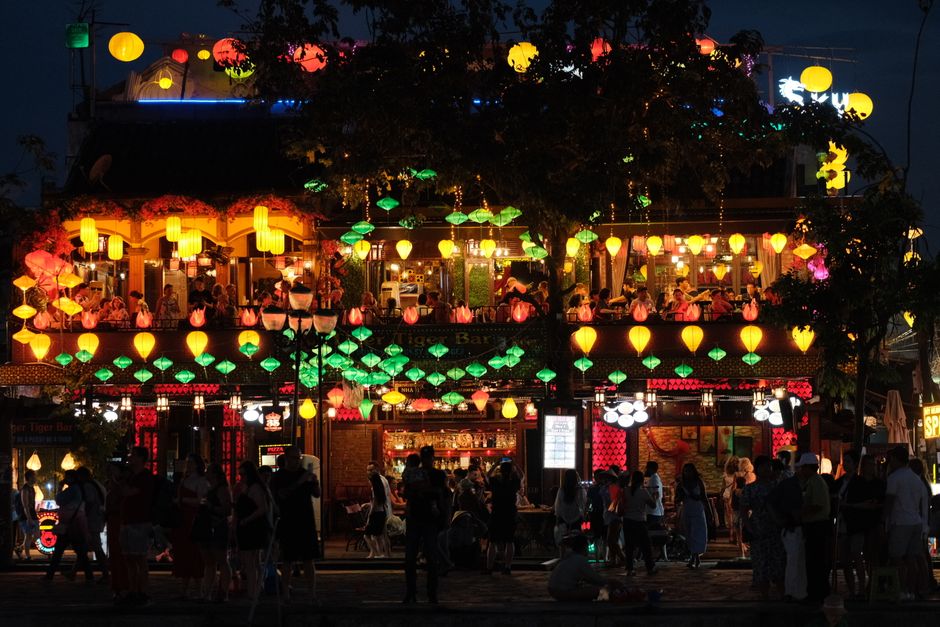 Colorful lanterns light up a lively night market scene, capturing the vibrant atmosphere.
