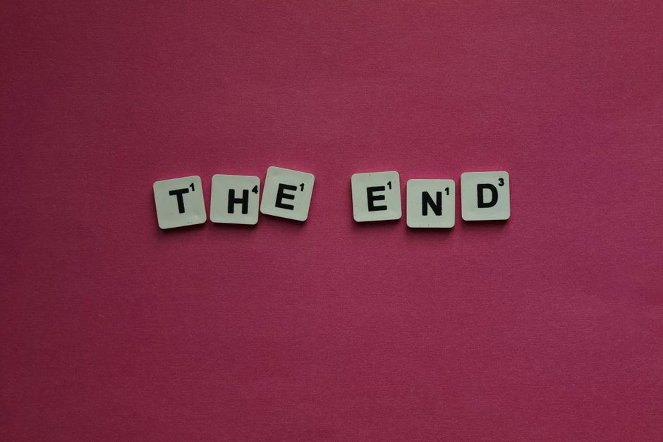 鮮やかなピンクの背景にスクラブルの文字で「The End」と書かれています。