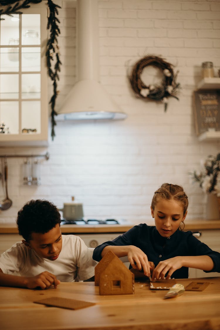 Boy And Girl Making A Gingerbread House