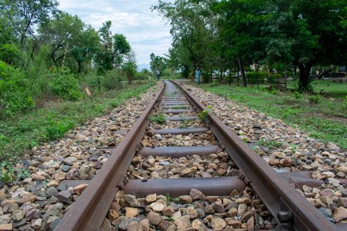 Free Long stretch of rustic railway tracks surrounded by lush greenery, invoking a sense of travel and exploration. Stock Photo