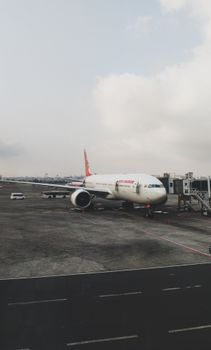 Air India Boeing 777 parked at Mumbai's Chhatrapati Shivaji Airport during the day.