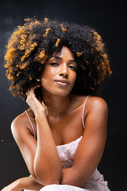 Free Artistic portrait of a woman with curly hair in São Paulo studio setting. Stock Photo