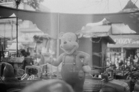 Black and white image of a vintage amusement park featuring a classic cartoon mascot statue.