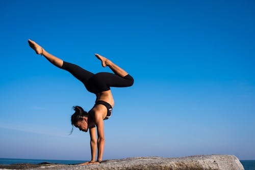 Free Woman With Arms Outstretched Against Blue Sky Stock Photo