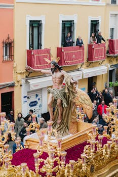 Capturing the vivid Semana Santa parade in Seville with Nazarenos carrying an elaborate religious float.