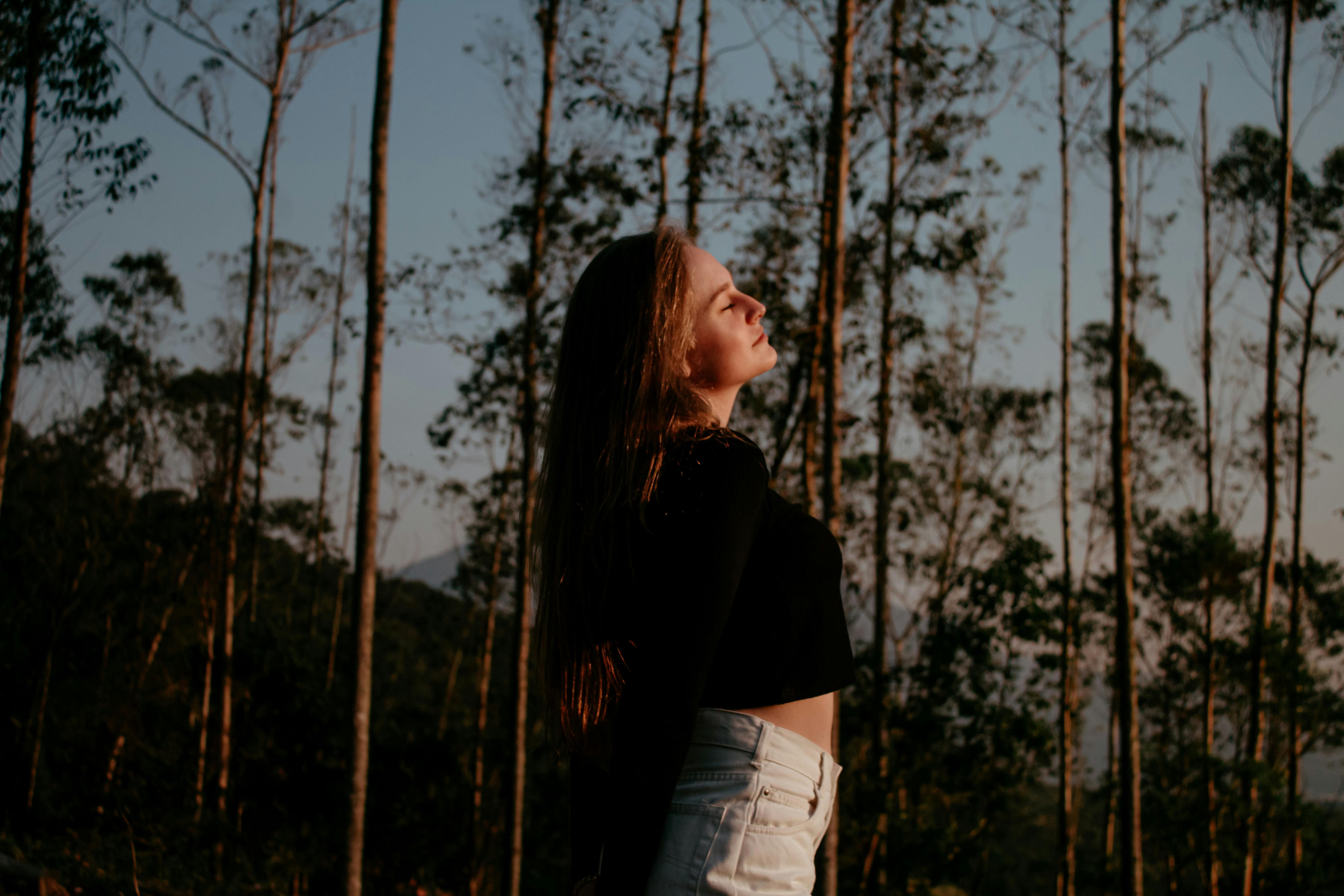 Portrait of a woman enjoying nature and freedom in a forest setting.