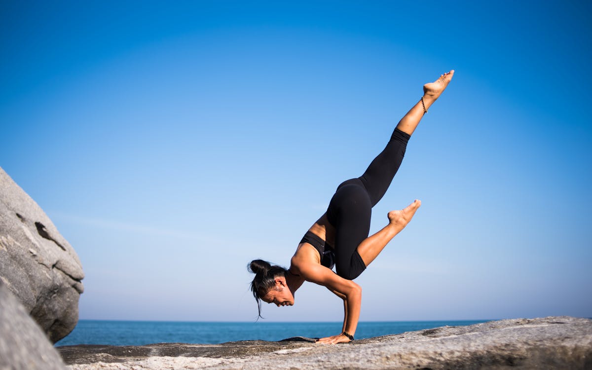 woman doing yoga on the beach 