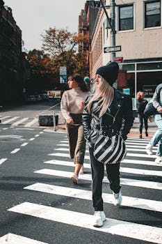 城市中，人们穿过斑马线，背景是建筑物