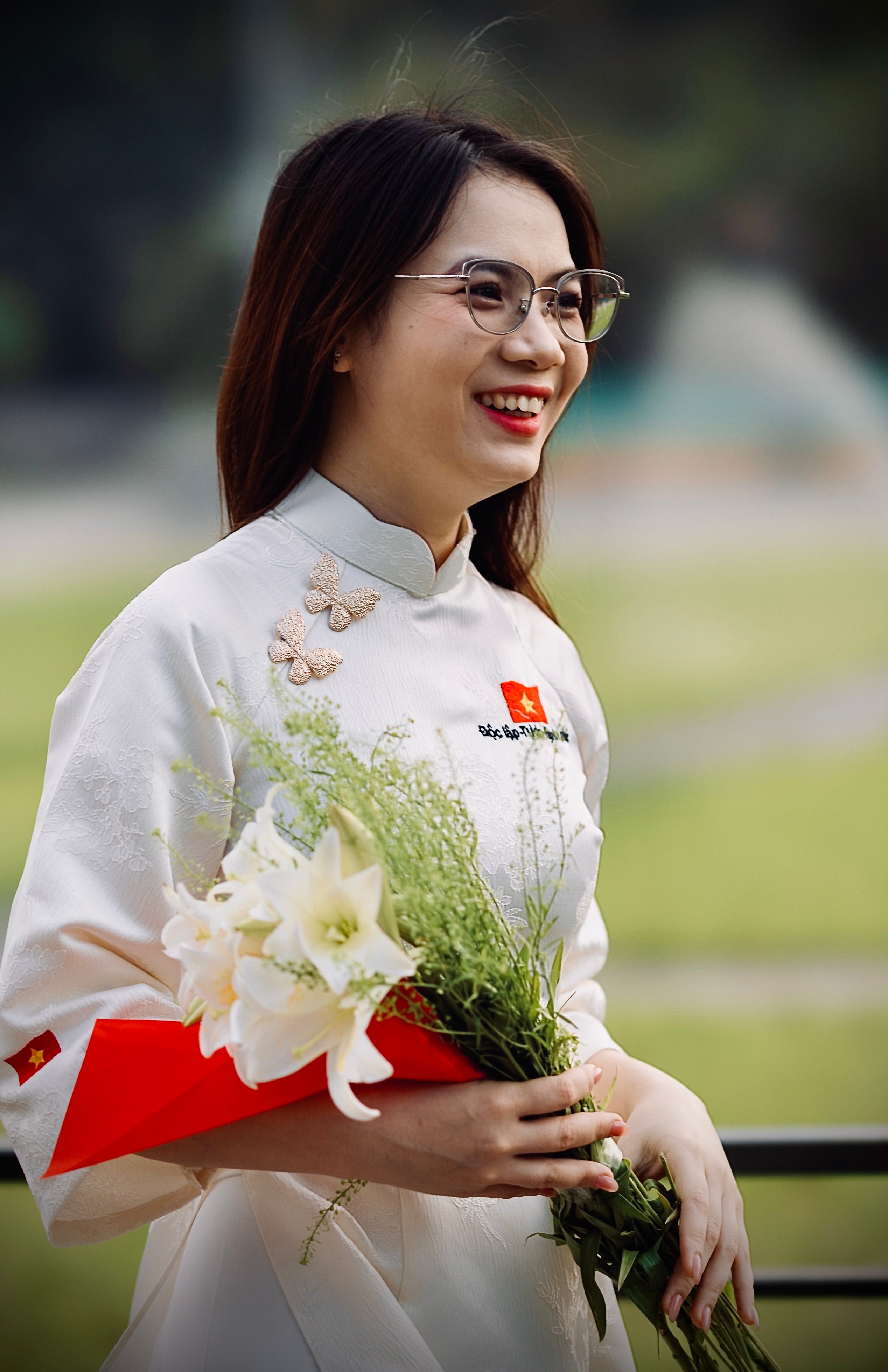 Woman in Traditional Dress Holding Flowers Outdoors