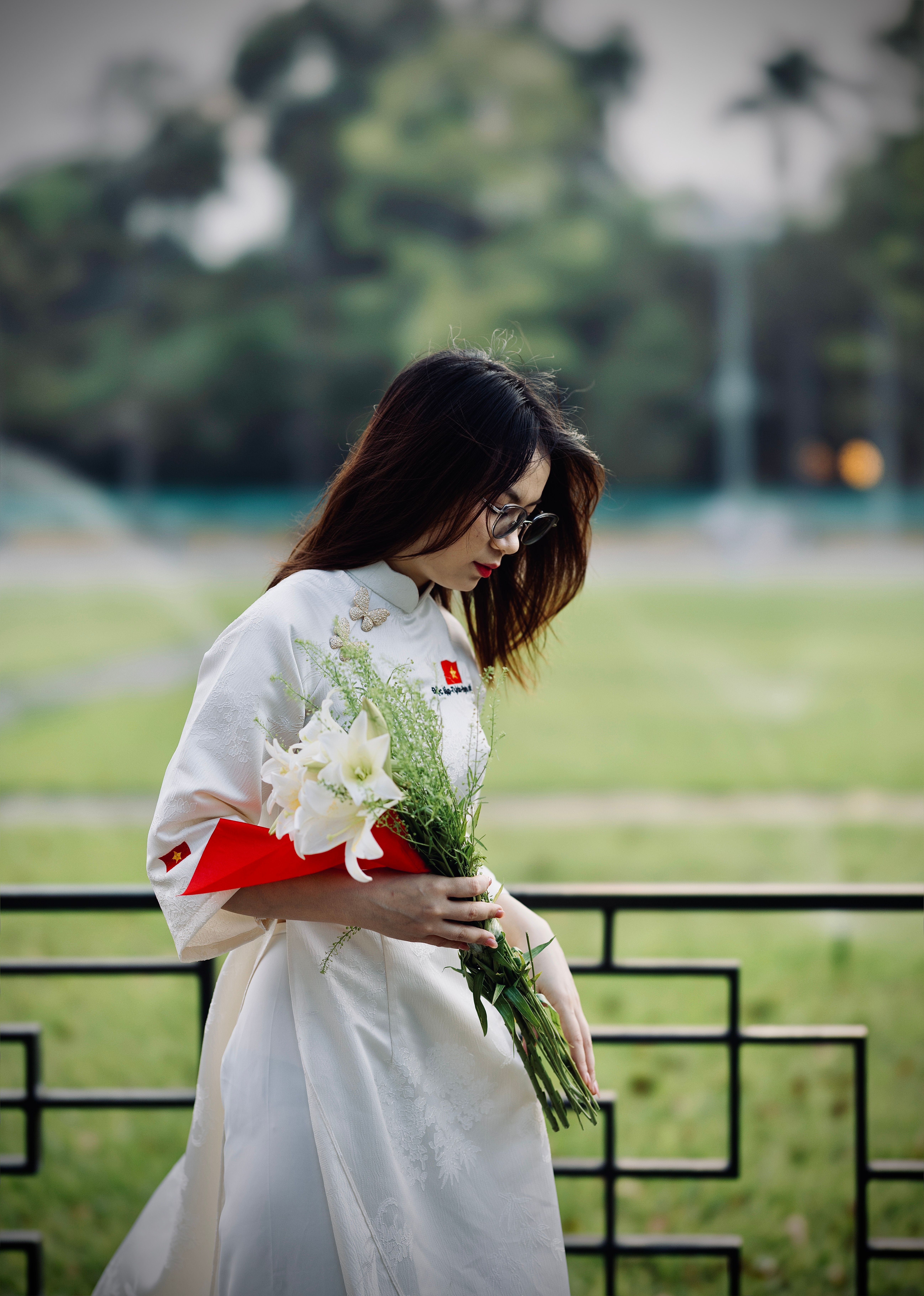 Young Woman in Traditional Dress Holding Flowers Outdoors · Free Stock ...