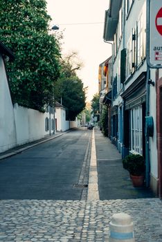 Quiet street in Basel, Switzerland with traditional architecture and cobblestone pathway.
