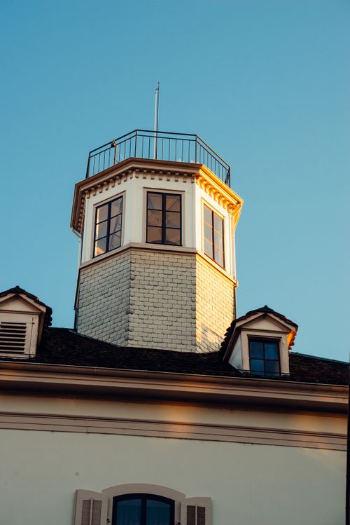 Free Elegant historic tower with hexagonal windows captured in Basel's warm sunset light. Stock Photo