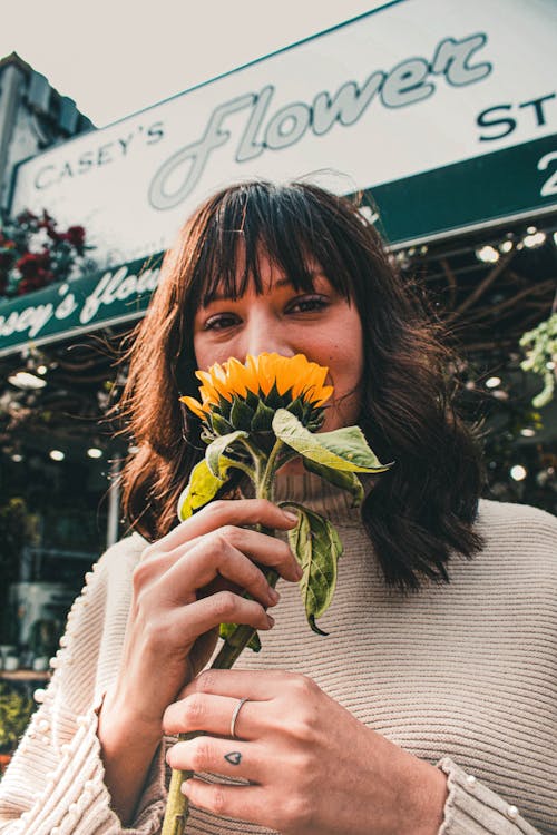Woman Holding Yellow Petaled Flower Near Casey's Flower Store
