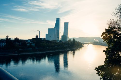 Free Captivating Basel skyline with modern architecture reflected in the Rhine at sunset. Stock Photo