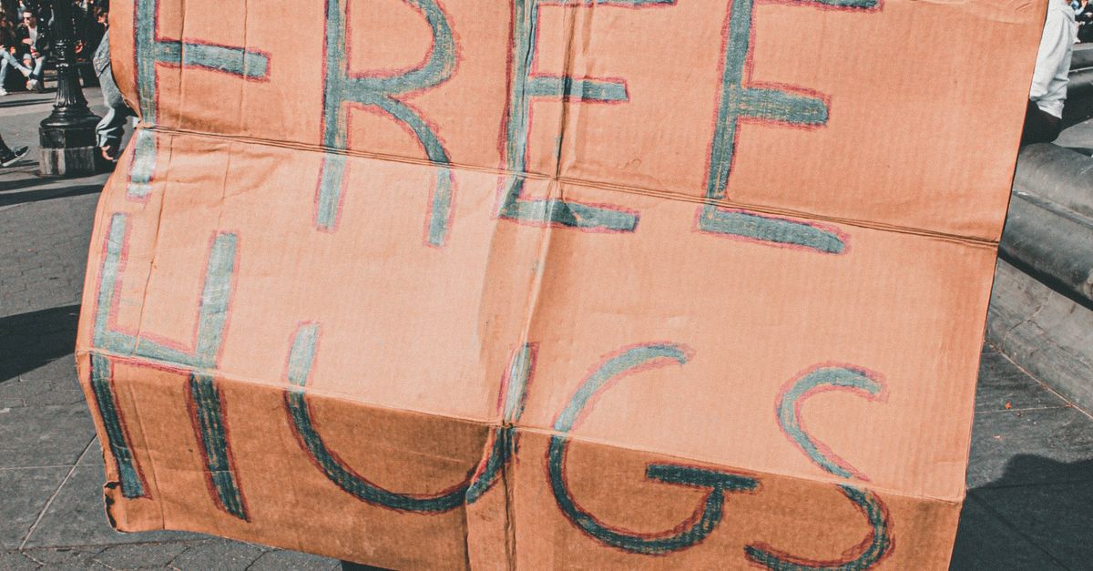 Hug Signage Man and Woman Holding Free Hugs Signage · Free Stock Photo