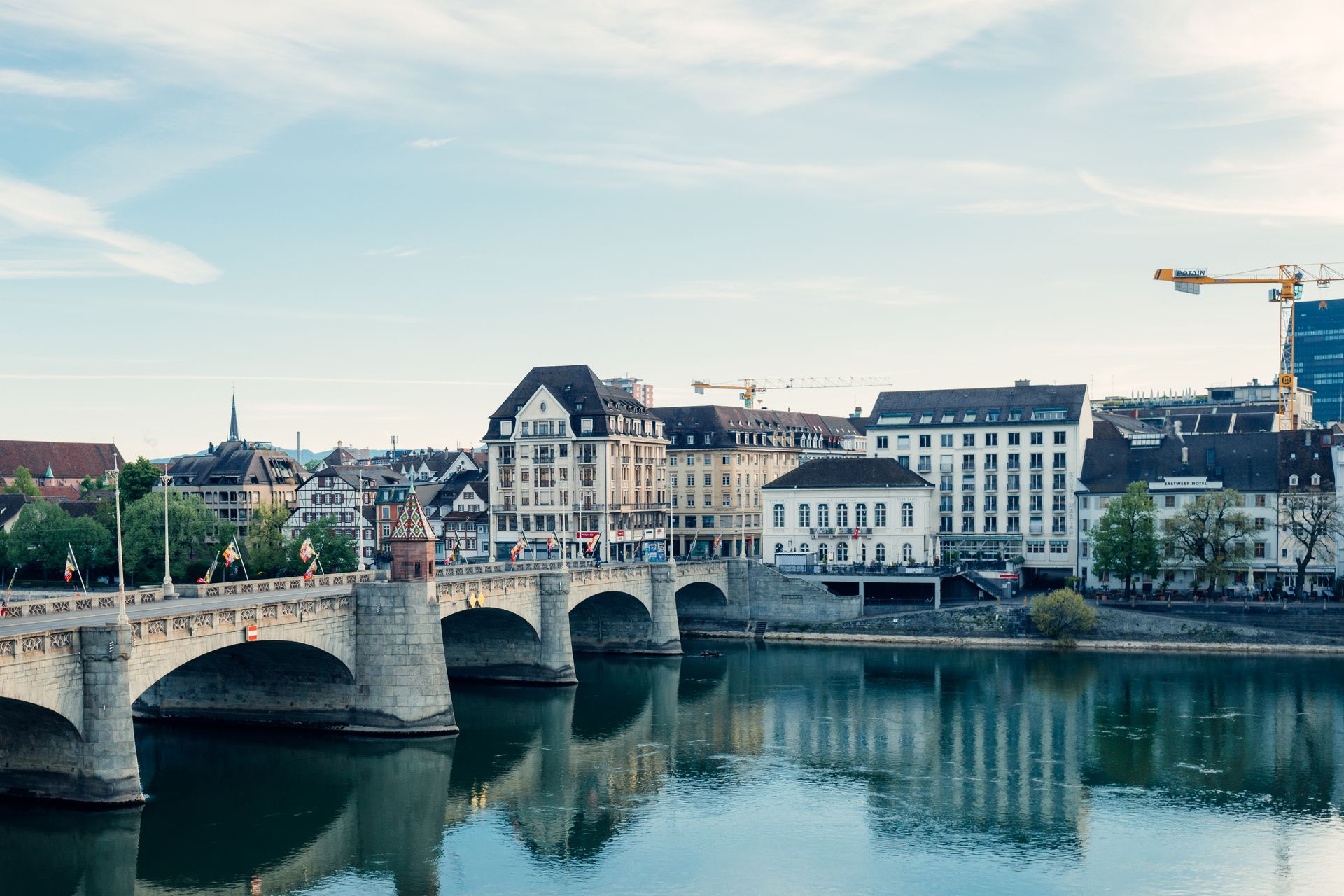 Scenic view of Basel city along the Rhine River showcasing architectural beauty and reflections.