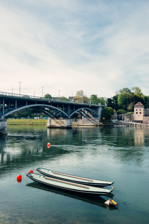 Free Two boats float peacefully under a bridge on the Rhine River in Basel, Switzerland. Stock Photo