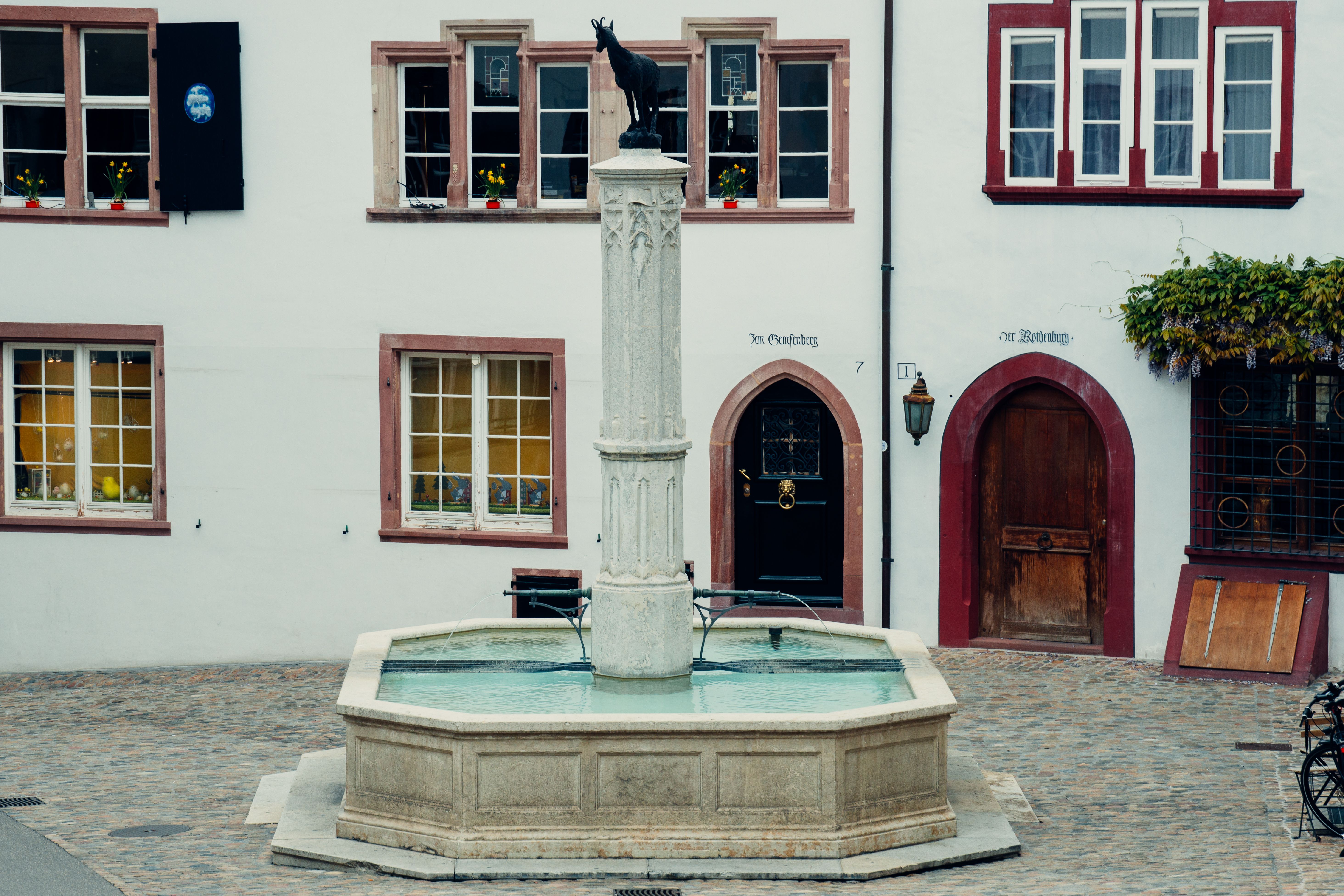 A picturesque fountain with a statue in Basel's historic square, surrounded by quaint architecture.