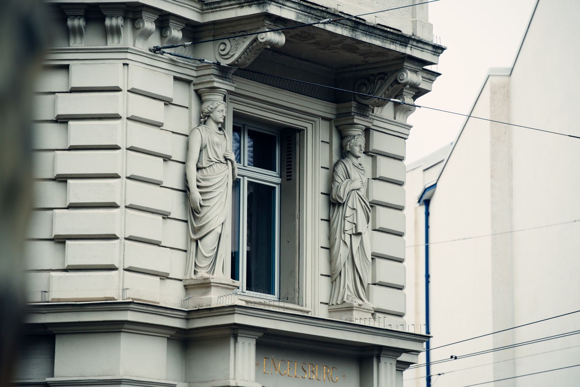 Detailed facade of a building in Basel showcasing ornate statues and classic architecture.