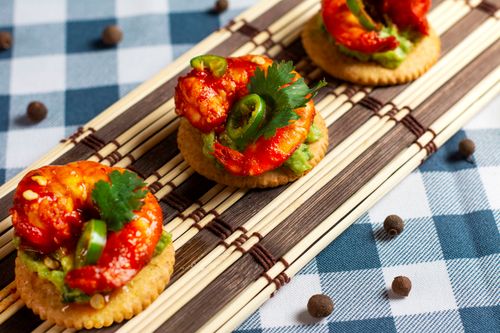 Free Delicious spicy shrimp with avocado and jalapeño on crackers, perfect gourmet snack. Stock Photo