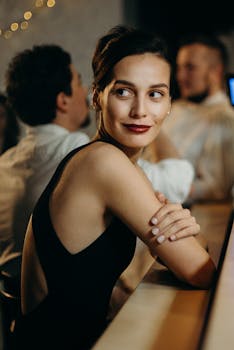 在别致的酒吧环境中，一位时尚女士微笑着转身，捕捉到温暖的夜晚氛围