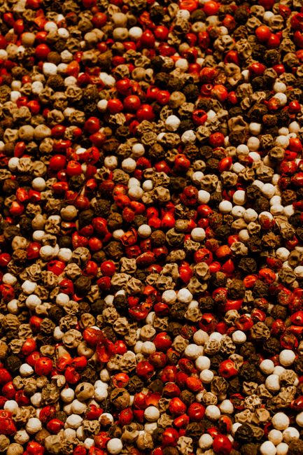 Fotomural Primer plano vibrante de granos de pimienta mixtos que muestran variedades rojas, blancas y negras.