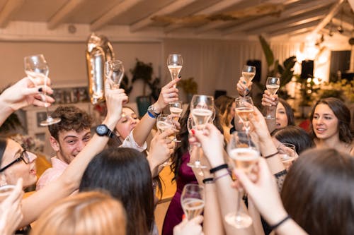 Happy friends clinking glasses with champagne in restaurant