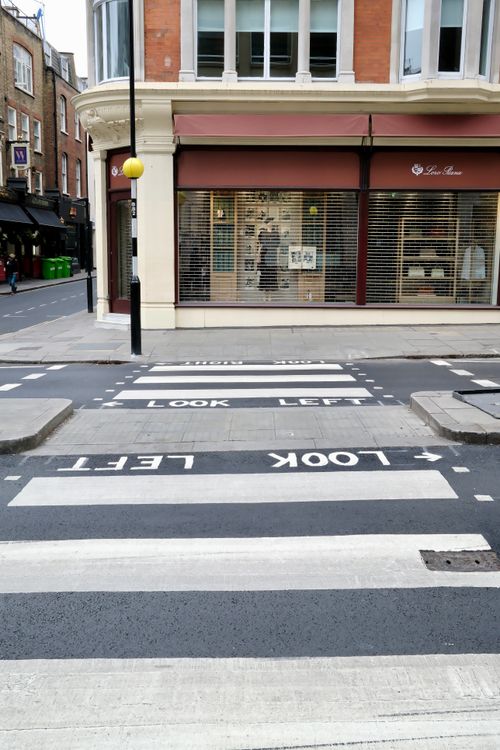 Free A city street crosswalk with Look Left instructions in a busy urban area. Stock Photo