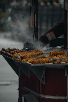 Steaming grilled corn on a street vendor cart, ideal street food scene.