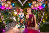 Birthday woman blowing candles on cake during celebration