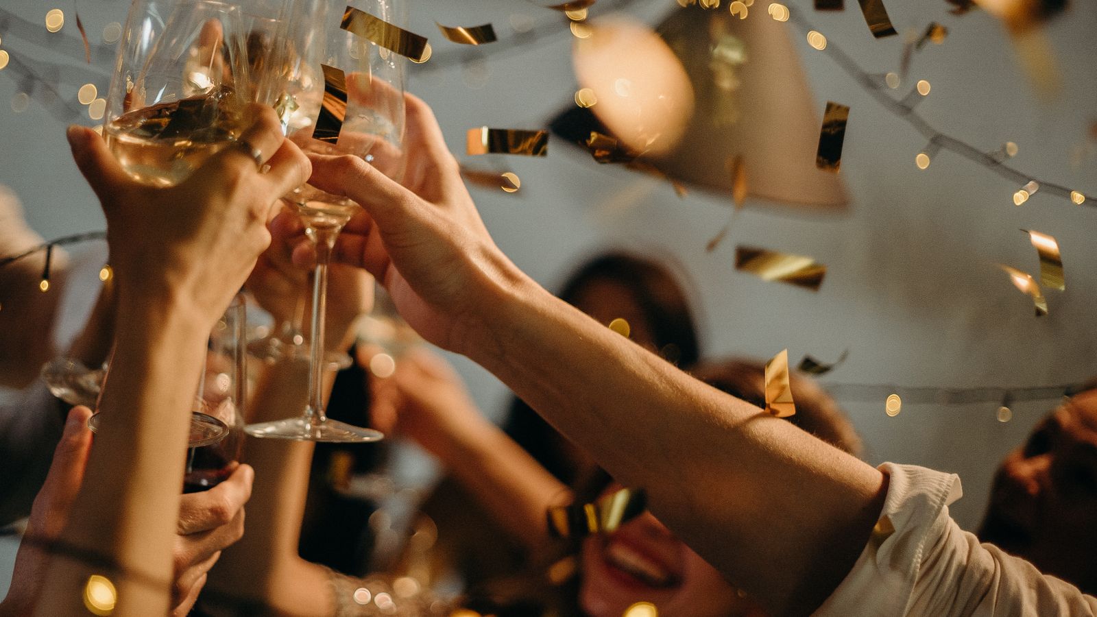 People toasting wine glasses at a festive celebration