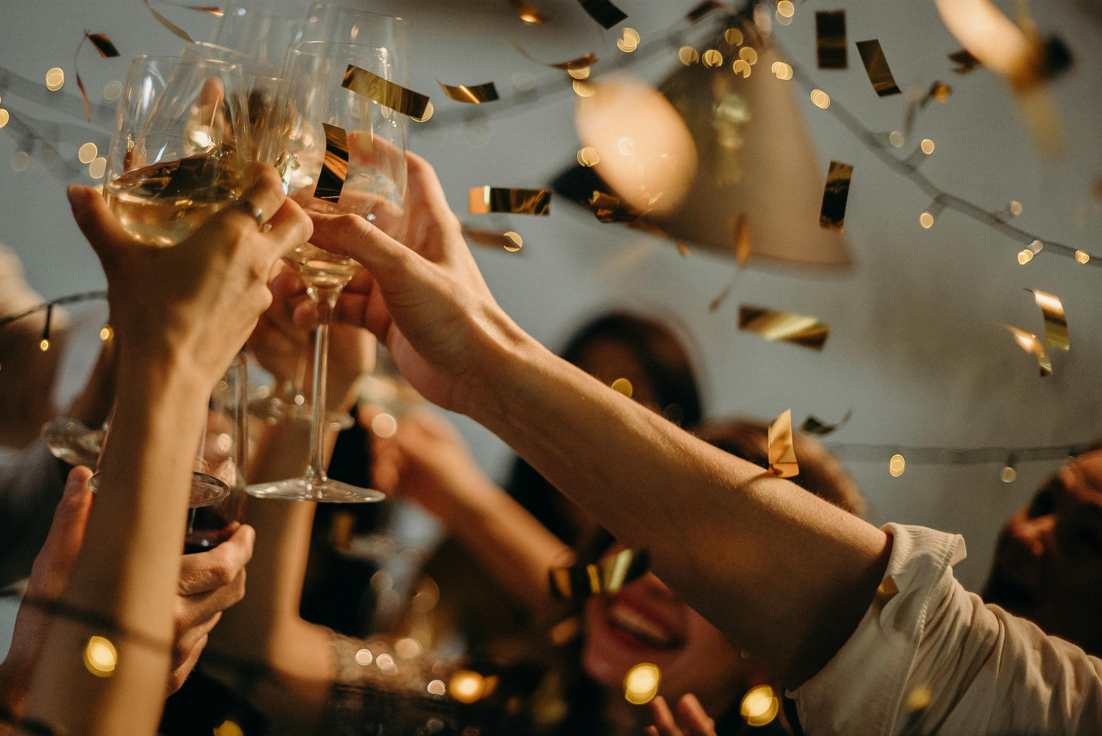People toasting wine glasses at a party. | Photo: Pexels