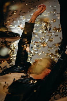 在节日派对上，一名男子躺在沾满五彩纸屑的地板上庆祝