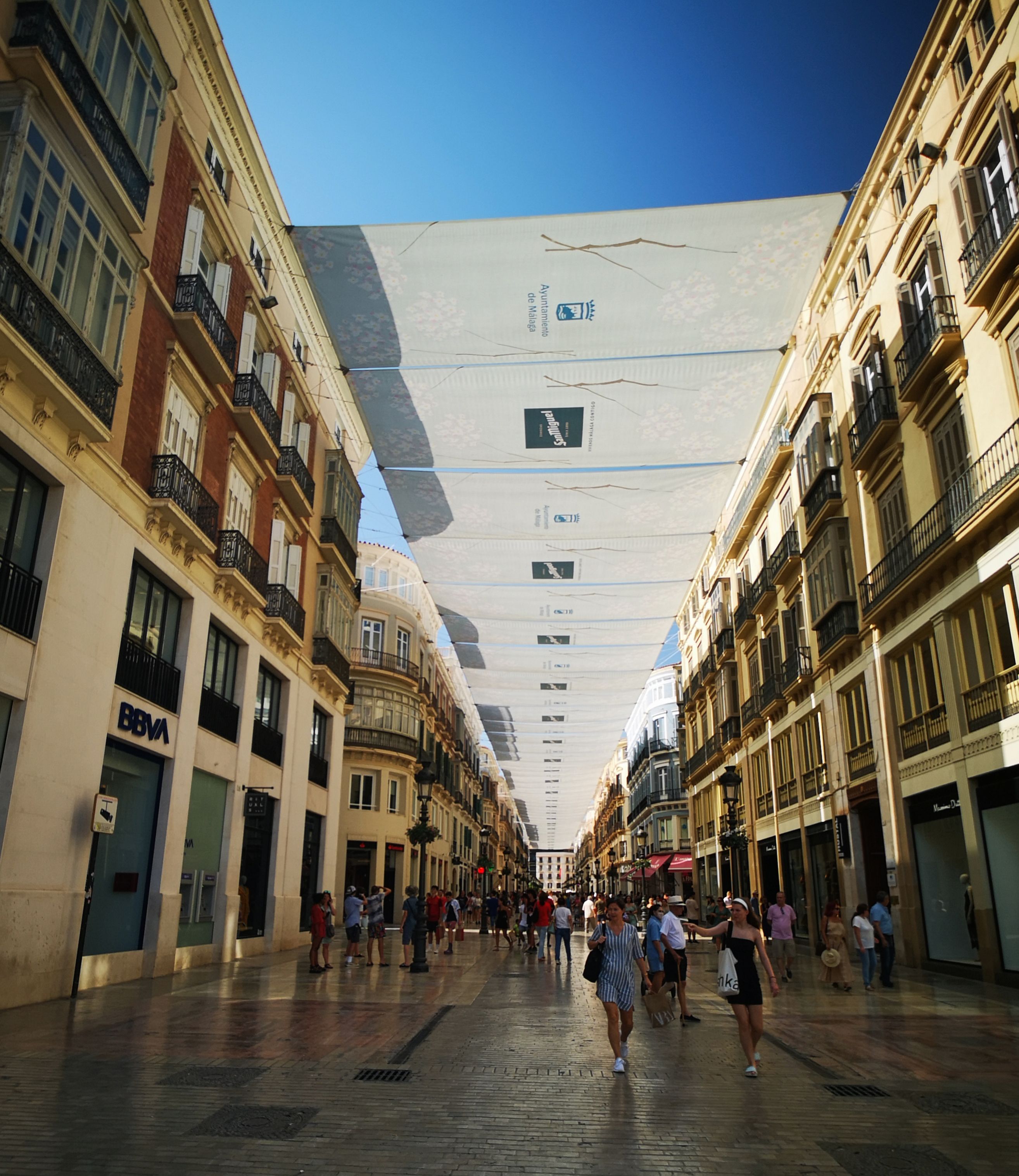 Calle Larios in Malaga with white awnings strung across the street between the buildings