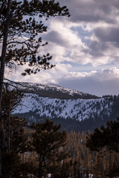 Free A breathtaking view of a snow-covered mountain under a dramatic cloudy sky. Stock Photo