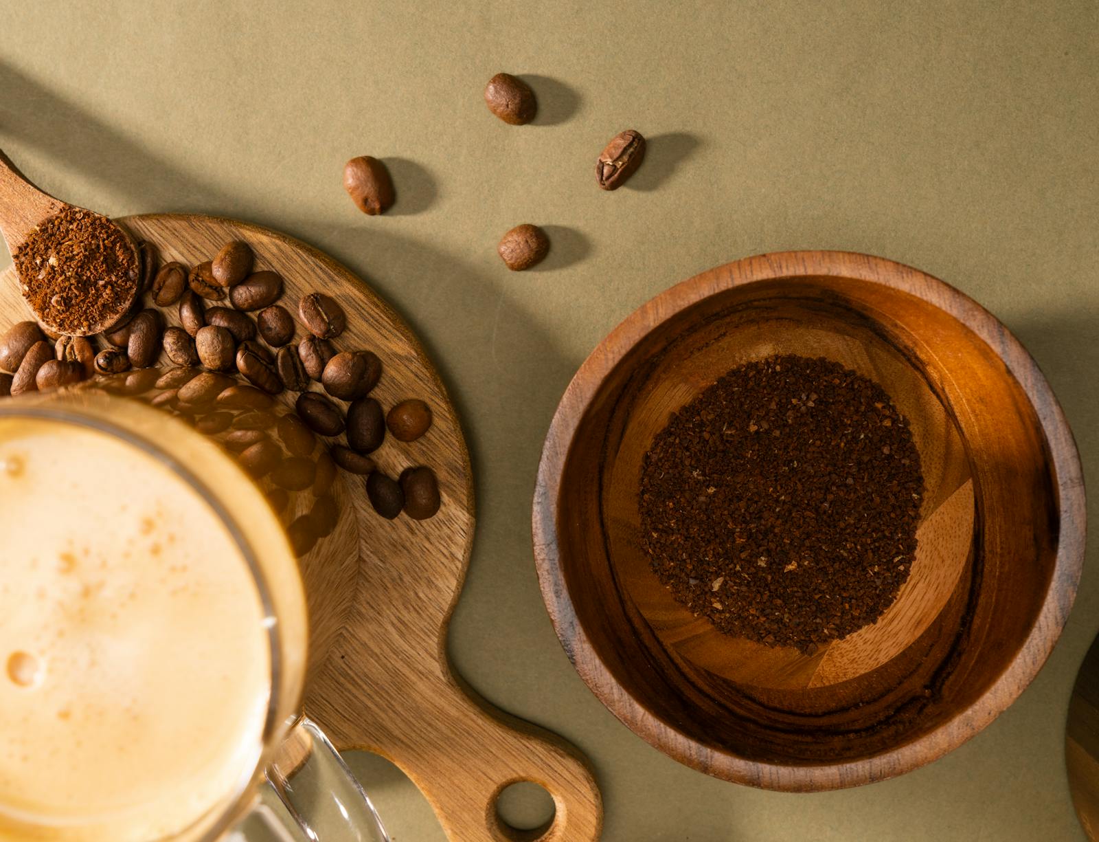 Flat lay of coffee beans, grounds, and a fresh brewed cup