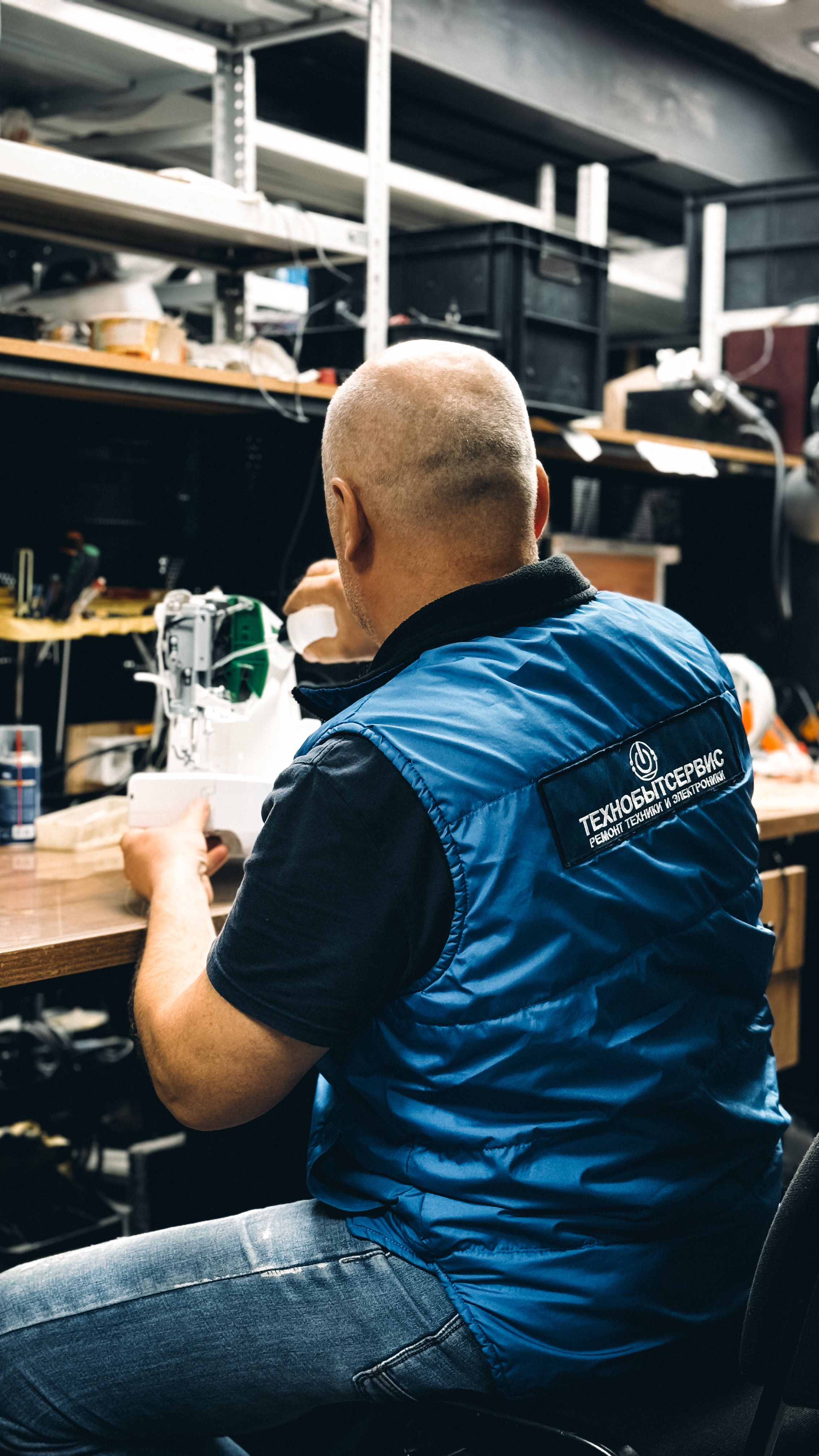 A skilled technician working in a workshop repairing electronic equipment.