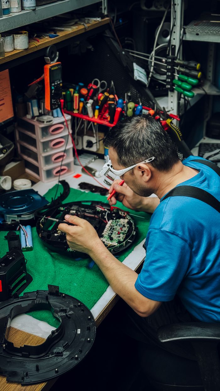 Technician inspecting a television's internal components before repair