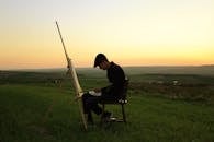 在日落期间，艺术家选择在宁静的田野上作画，他/她专注于描绘风景