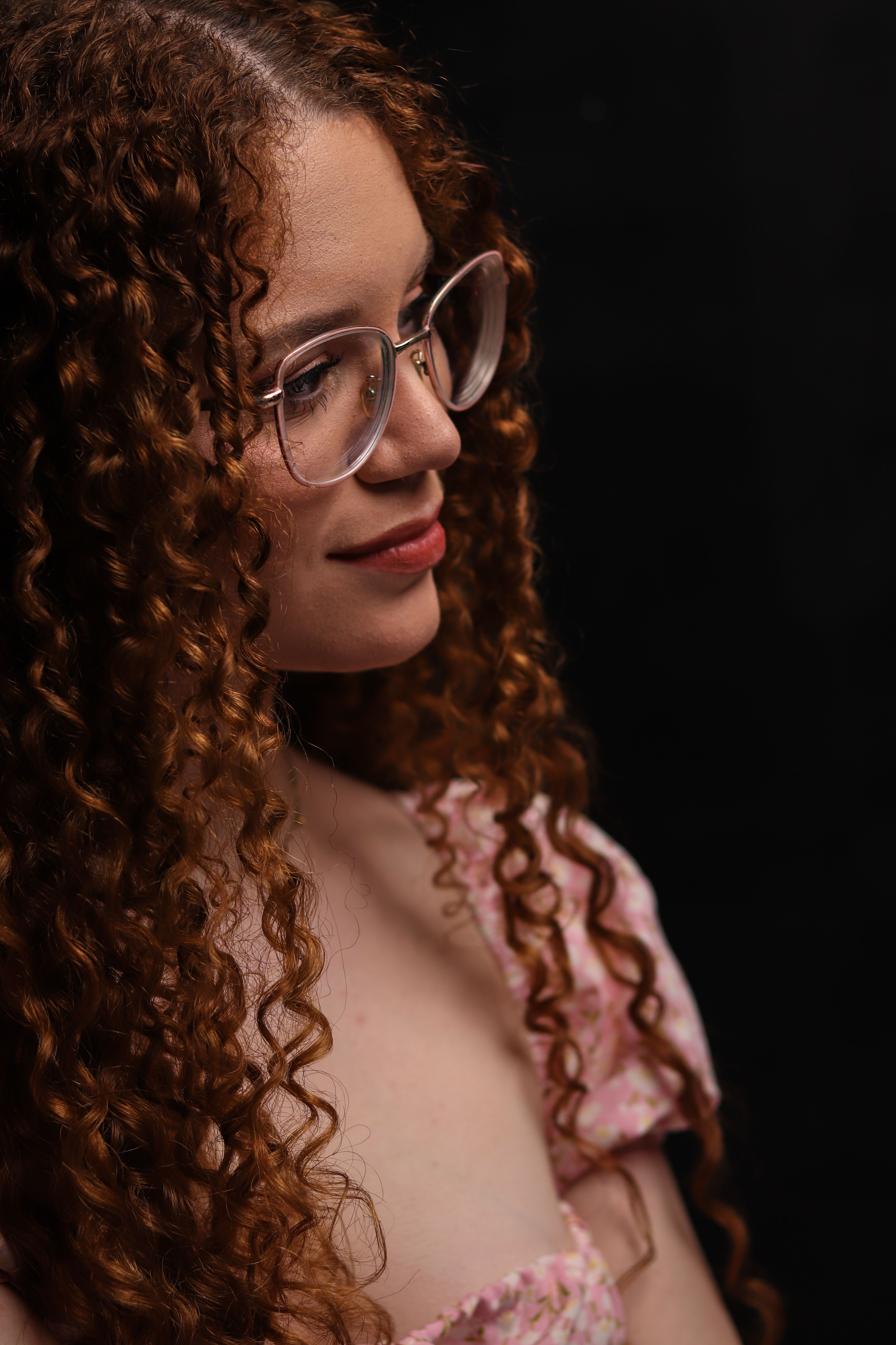 Portrait of a Woman with Curly Hair and Glasses · Free Stock Photo