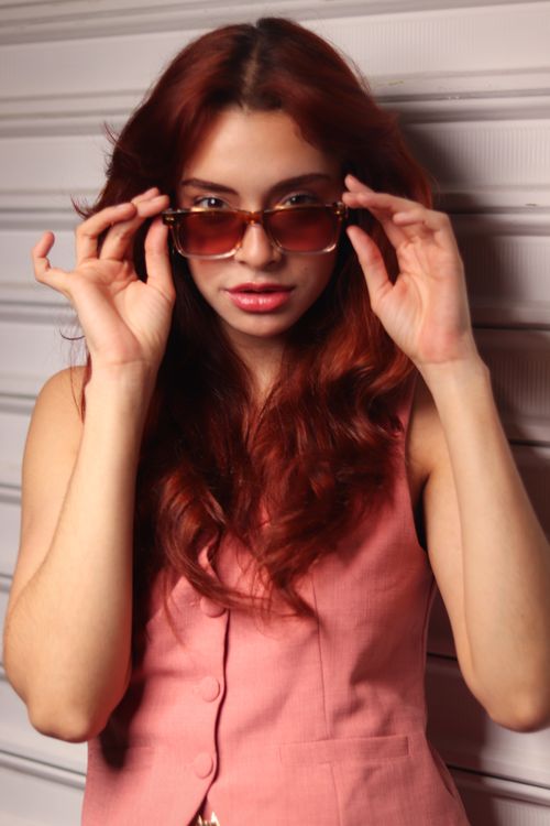 Free Young woman with sunglasses exuding confidence and style indoors. Stock Photo